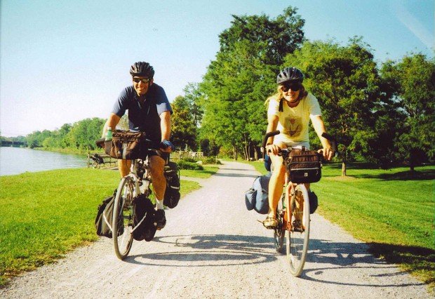 "Bicyclists having fun cycling near a lake"