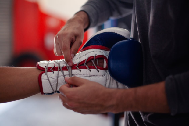 https://www.pexels.com/photo/a-person-tying-the-laces-of-a-boxing-glove-8810063/